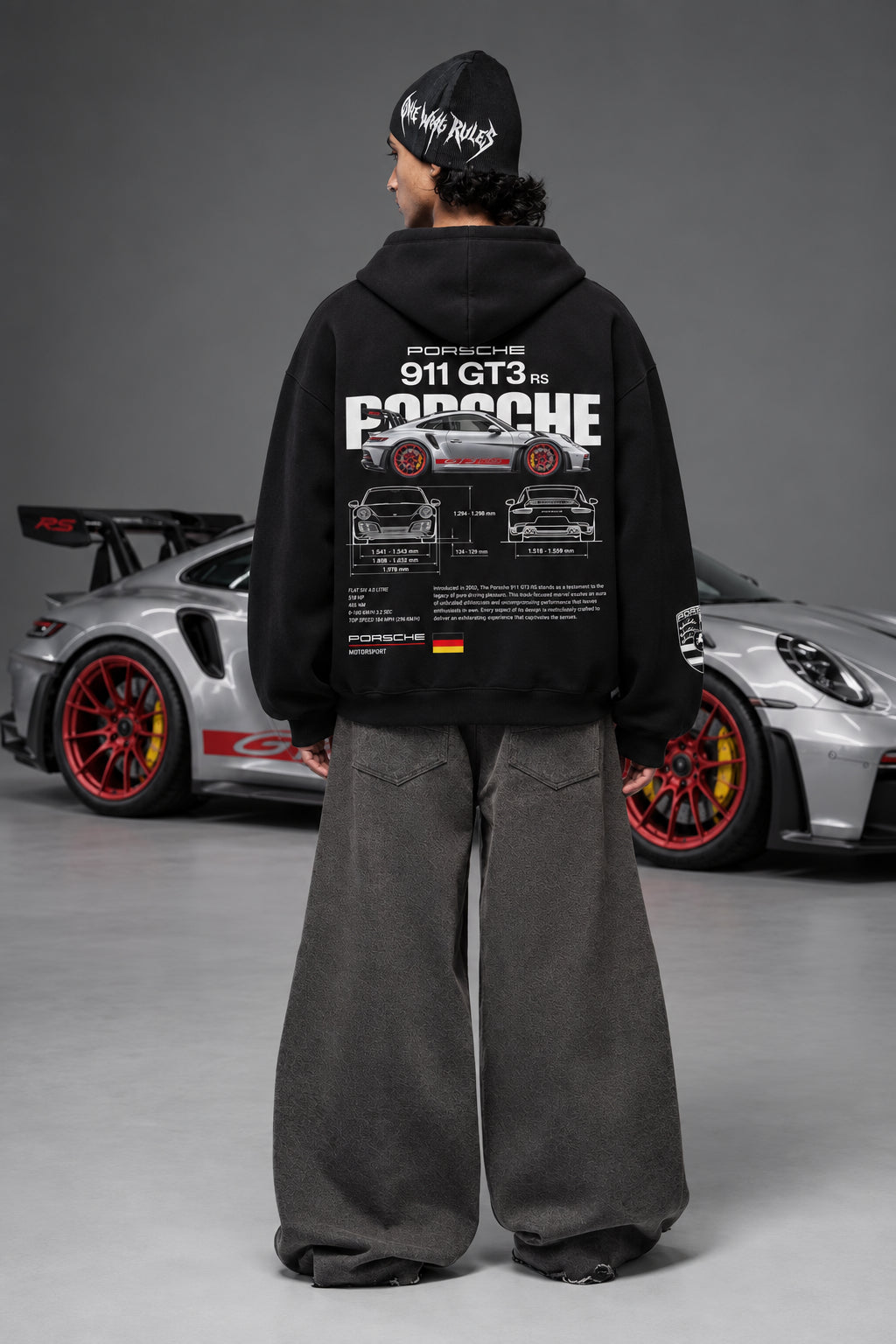Full back view of the Porsche 911 GT3 RS hoodie beside a Porsche car