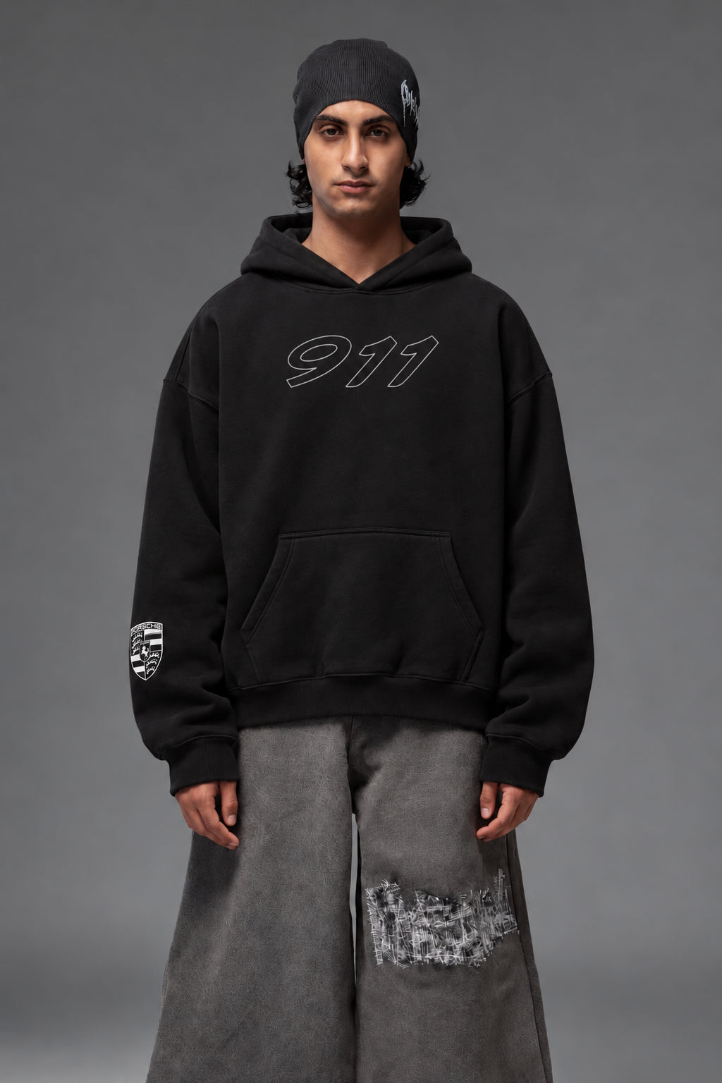 Front portrait of the black Porsche 911 oversized hoodie with outlined 911 chest graphic