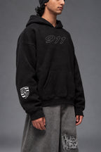 Three-quarter front view of the black Porsche 911 oversized hoodie