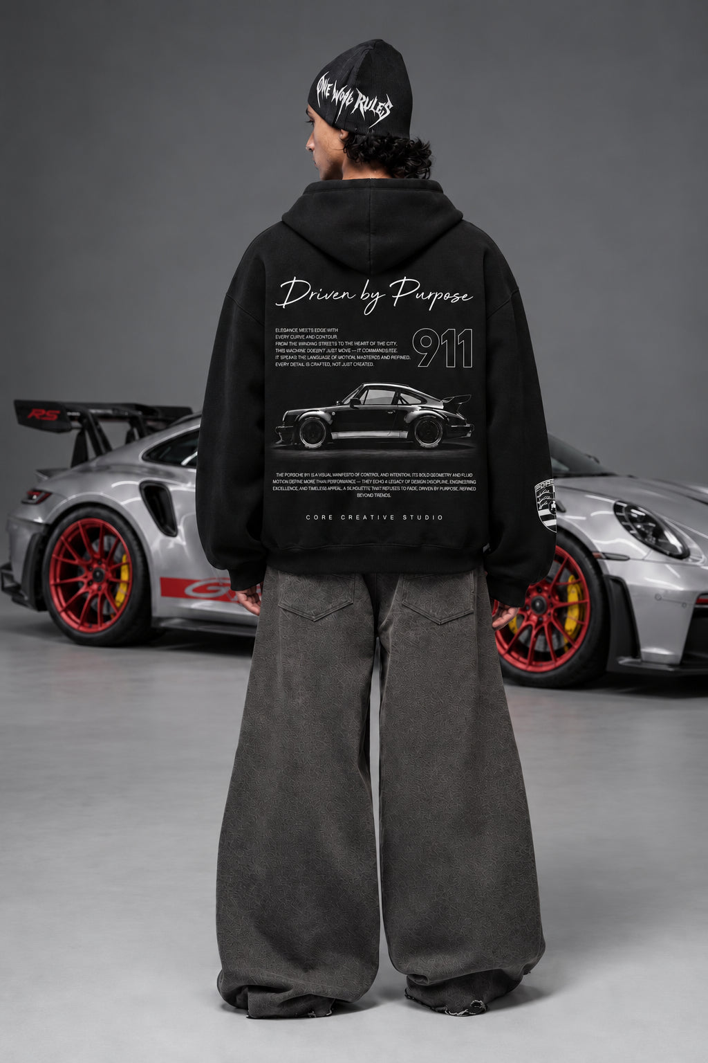 Full-length rear view of the Porsche 911 hoodie beside a Porsche car